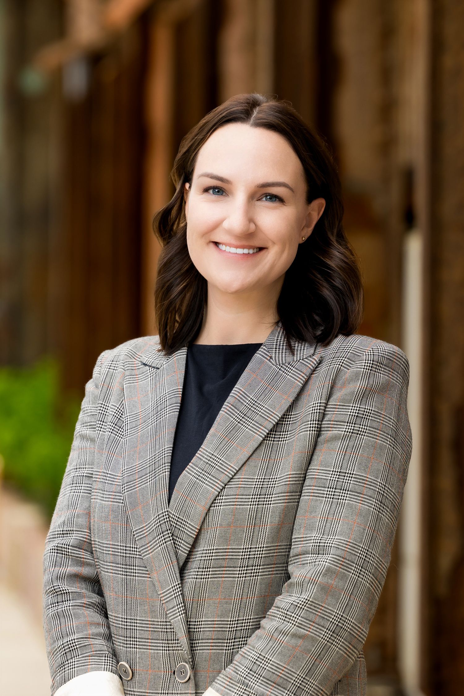 Professional headshots featuring a person wearing a plaid blazer in an outdoor setting.