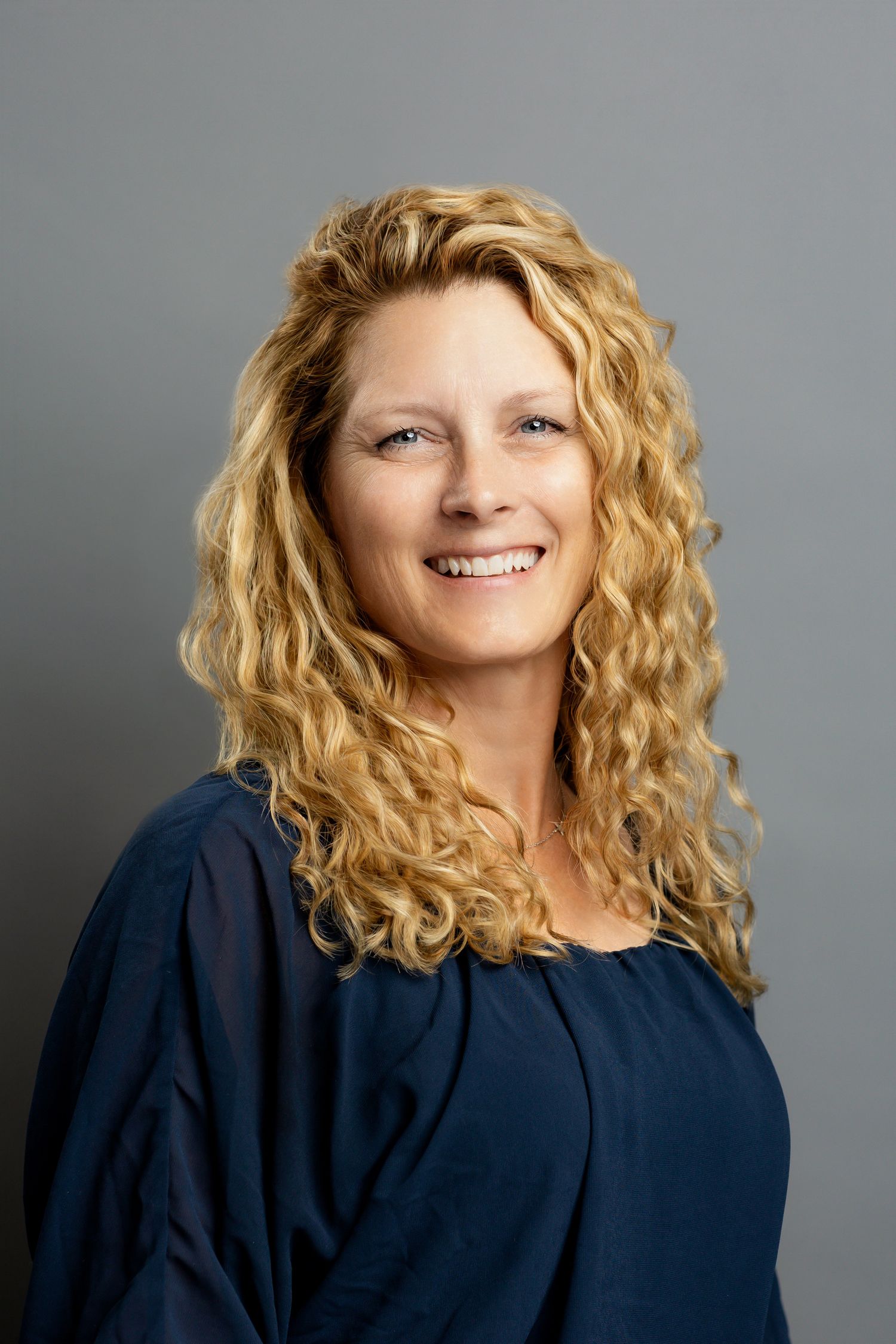 Professional portrait series showing joyful expressions and curly blonde hair against a gray background.