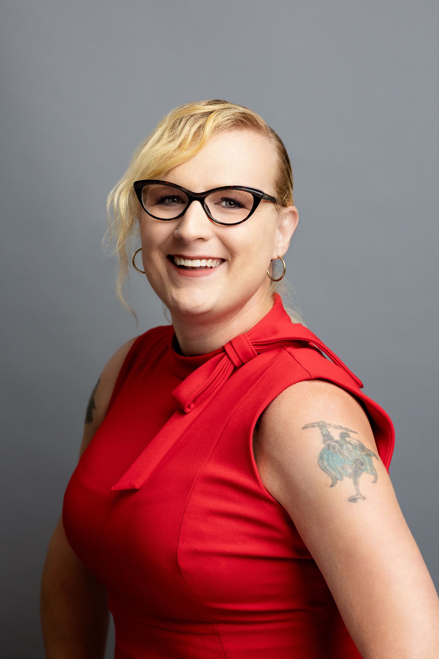Series of portraits showing person in red sleeveless top and cat-eye glasses with visible arm tattoo.