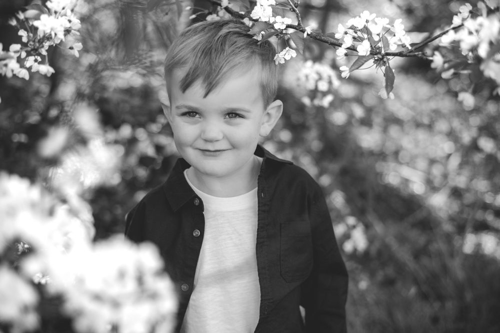 Black and white portrait surrounded by delicate spring blossoms.