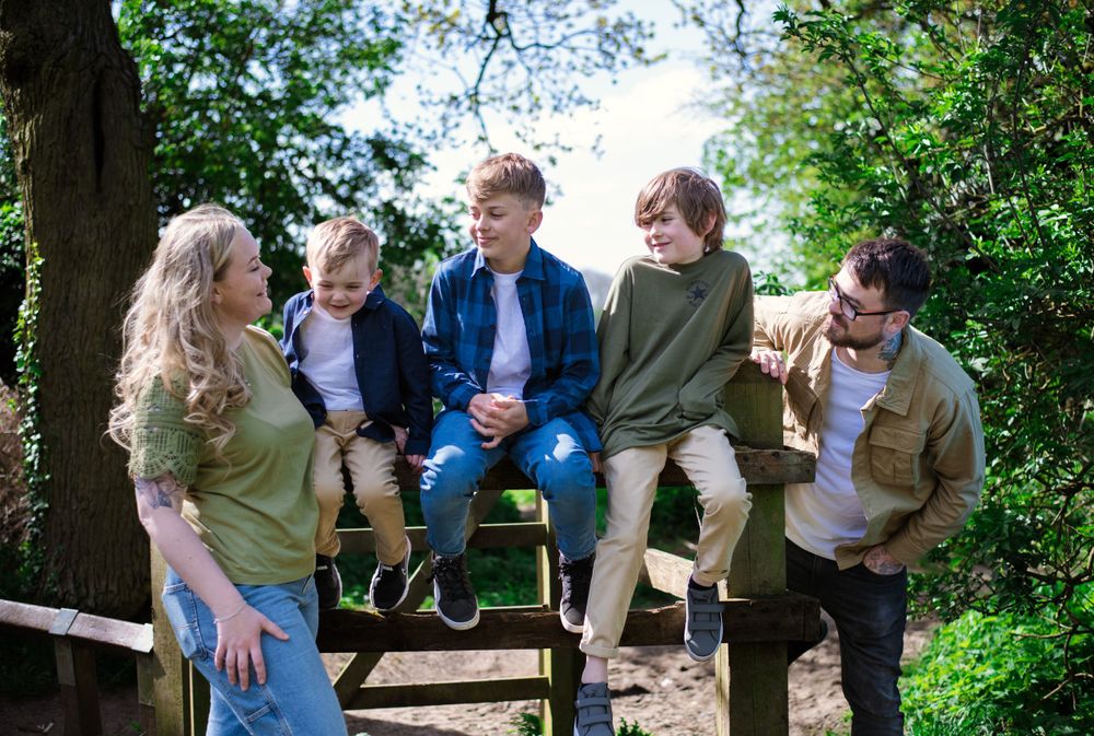A group relaxing together on a bench in a lush green park setting.