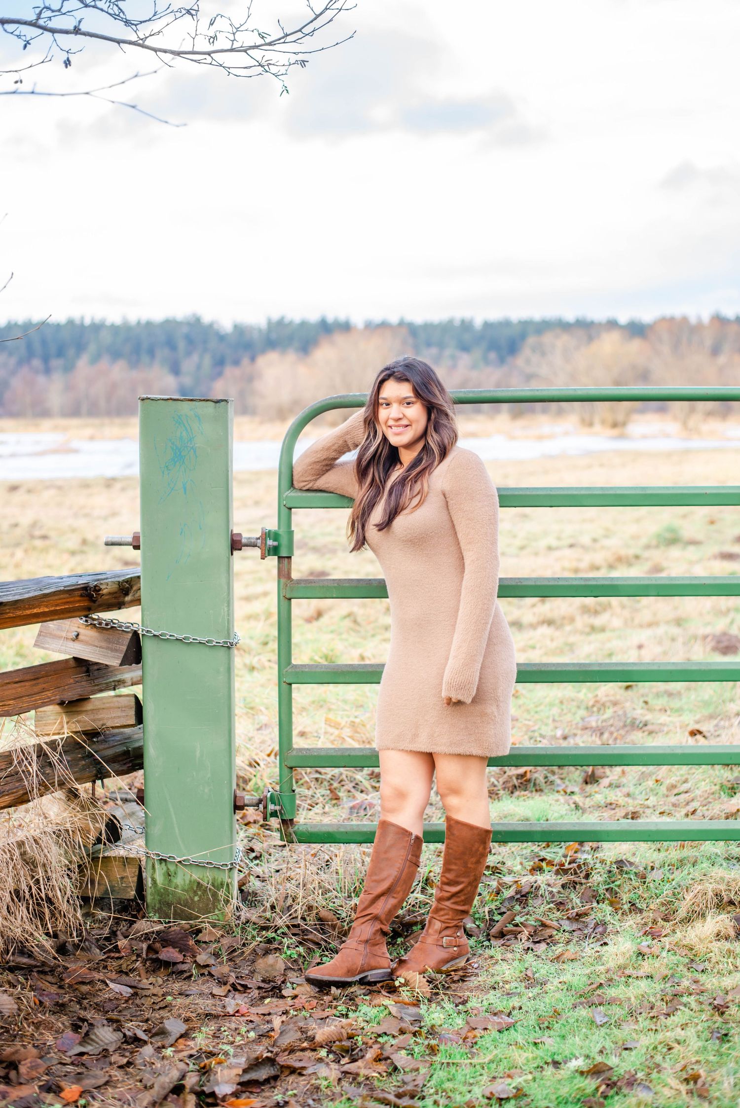 Brown boots and beige clothing shown against a green metal railing in an outdoor fall setting.