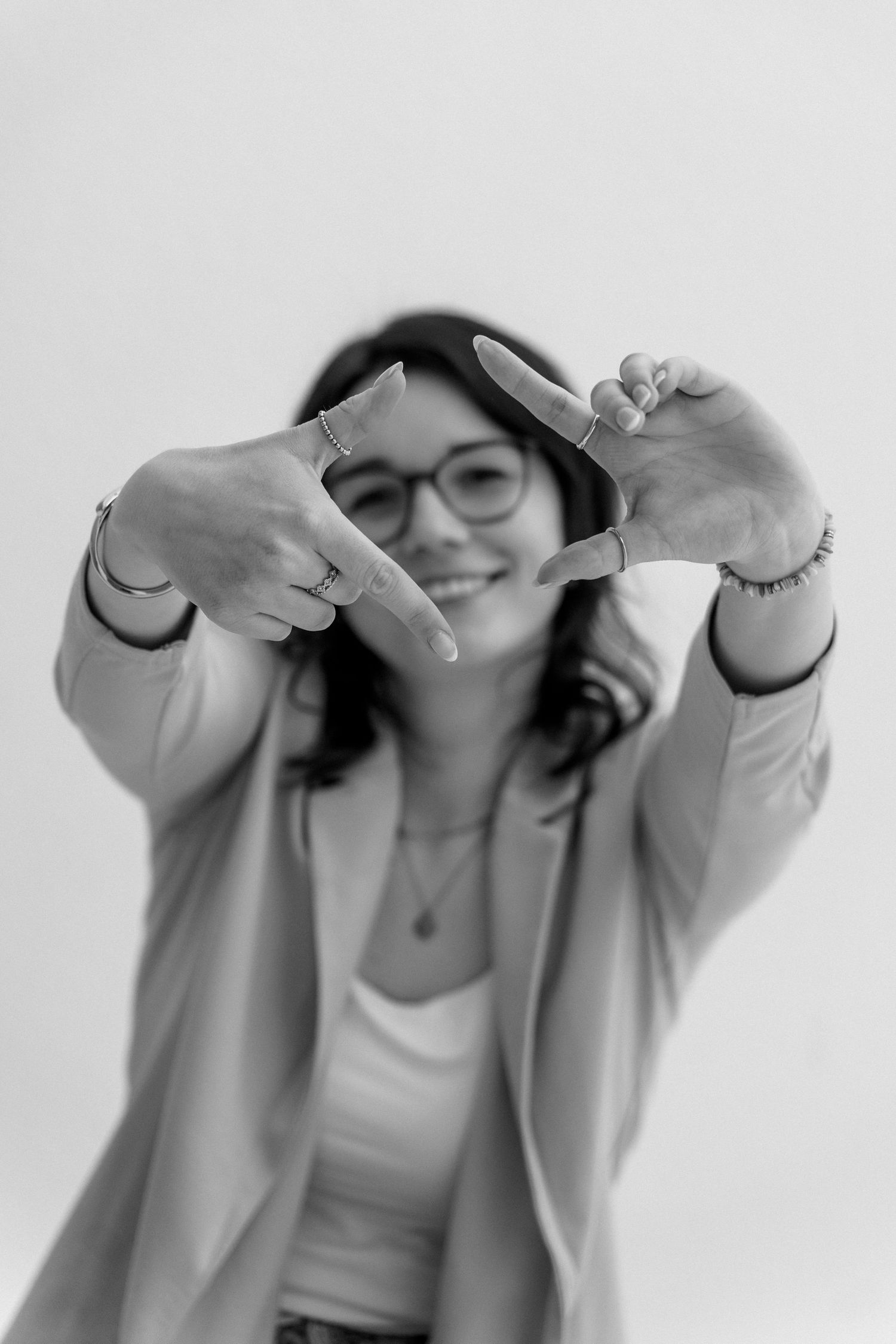 A series of four images showing someone in a white top making playful gestures and poses against a light background.