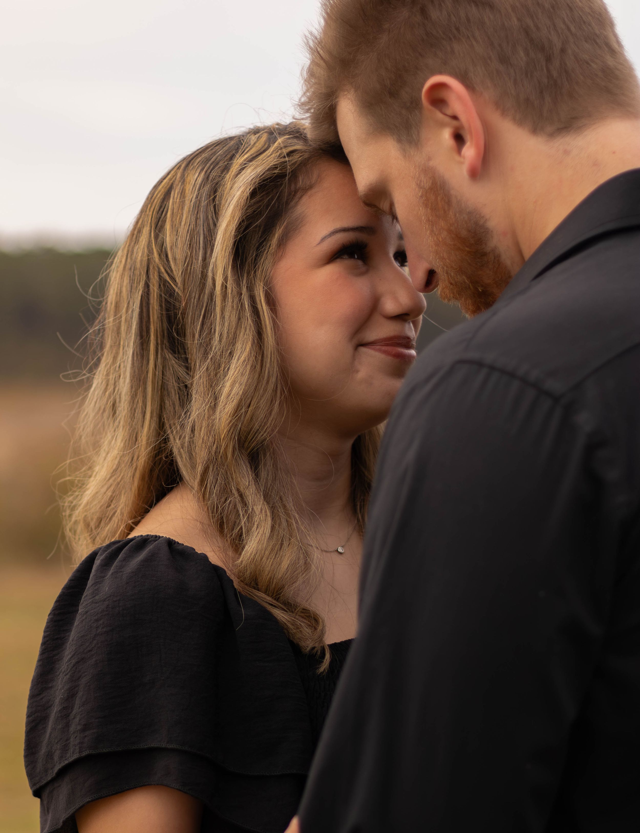 Romantic close-up of couple sharing intimate moment outdoors.