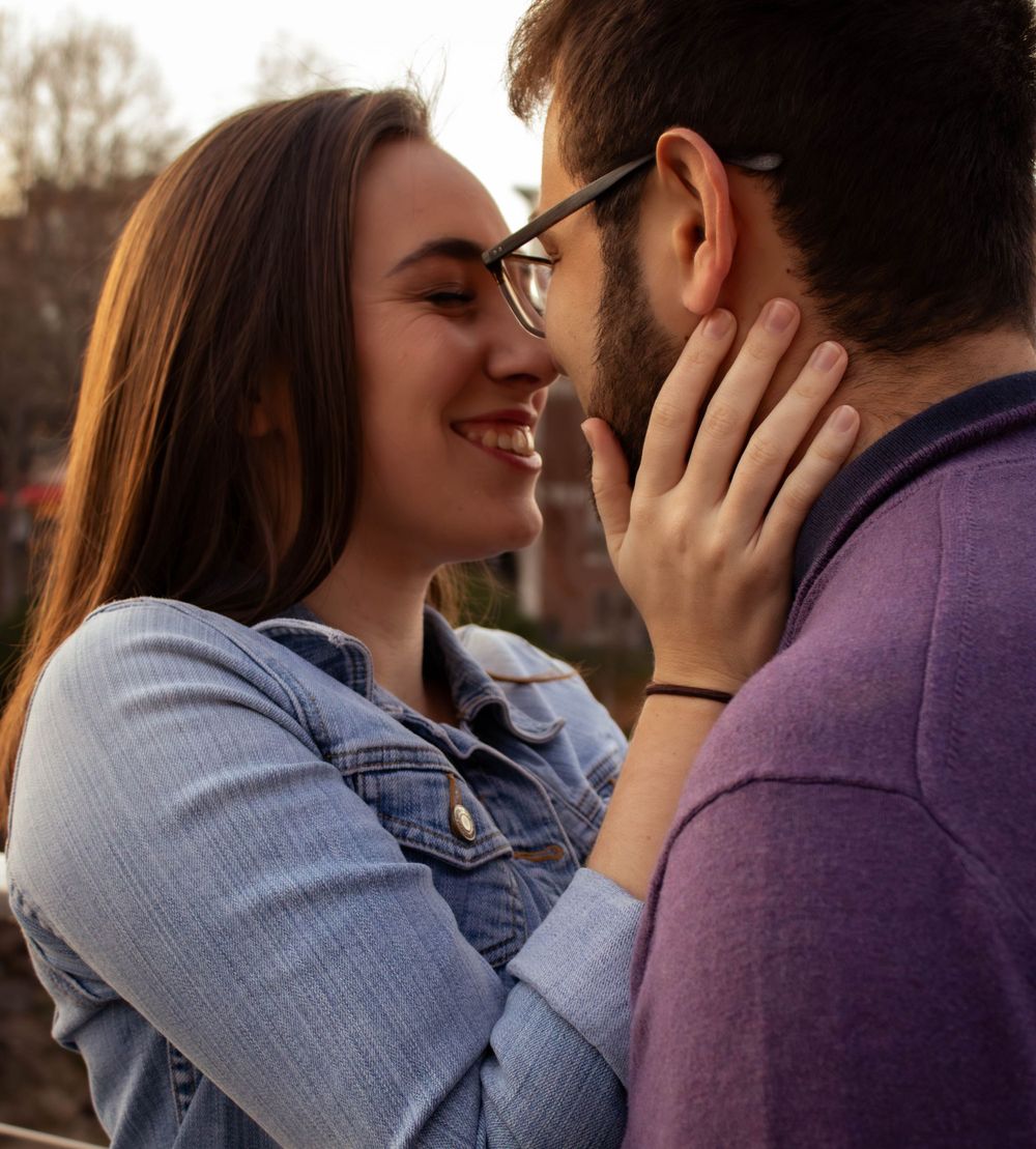 Intimate romantic couple sharing tender moment at sunset outdoors.