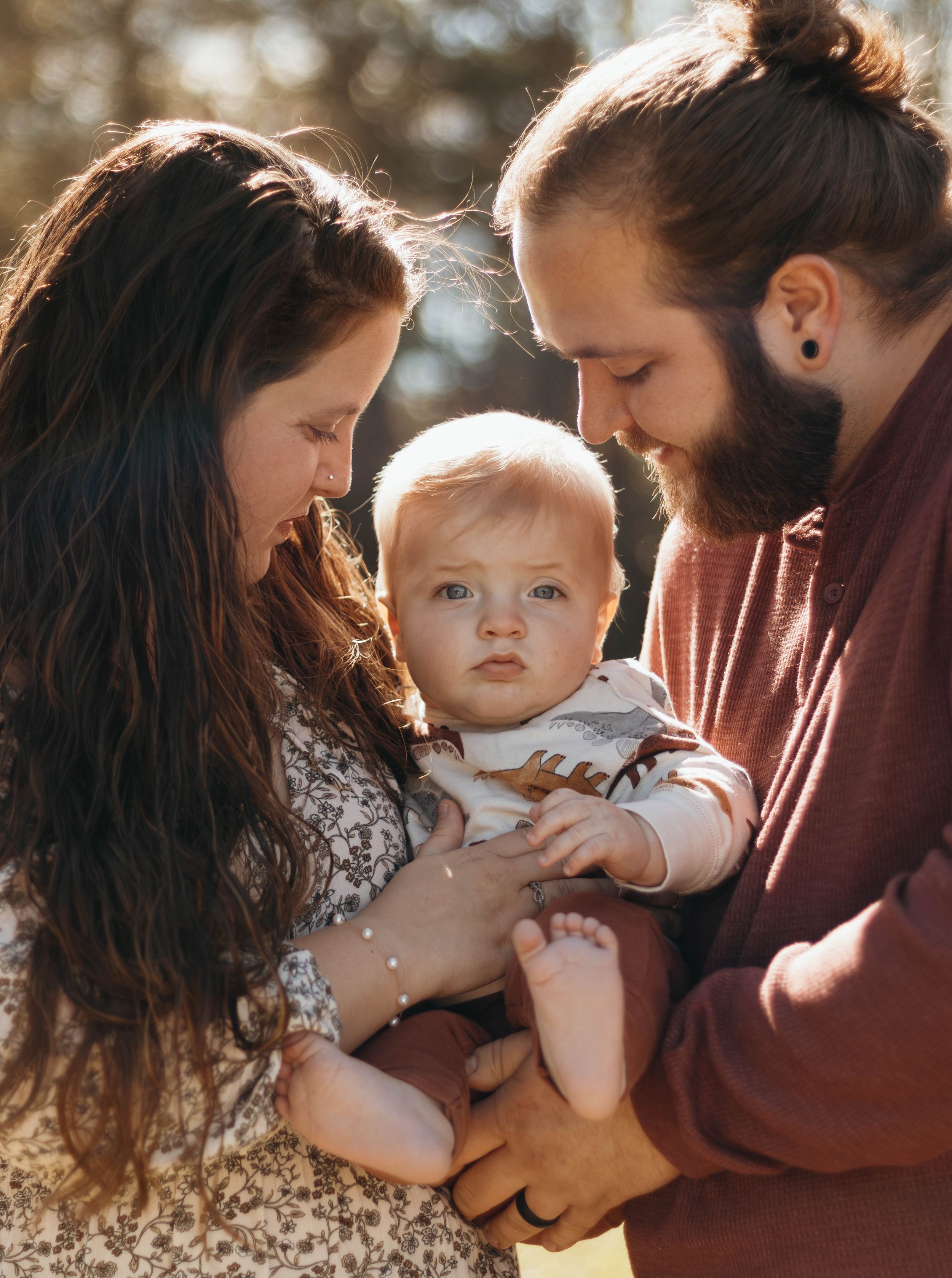 Intimate family moment captured in warm sunset lighting outdoors.