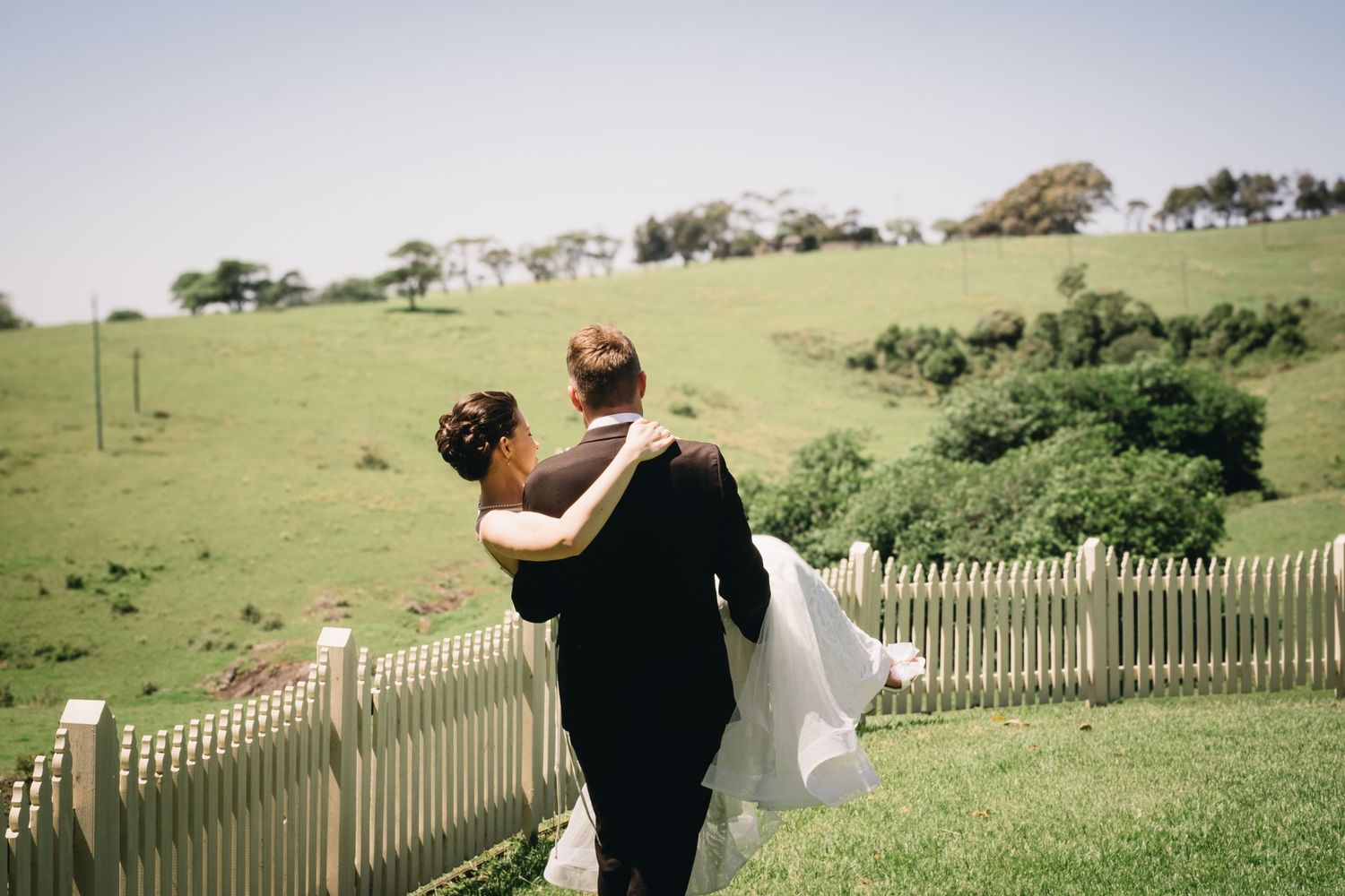 Wedding photography sequence on a hilltop with rolling green fields in the background.