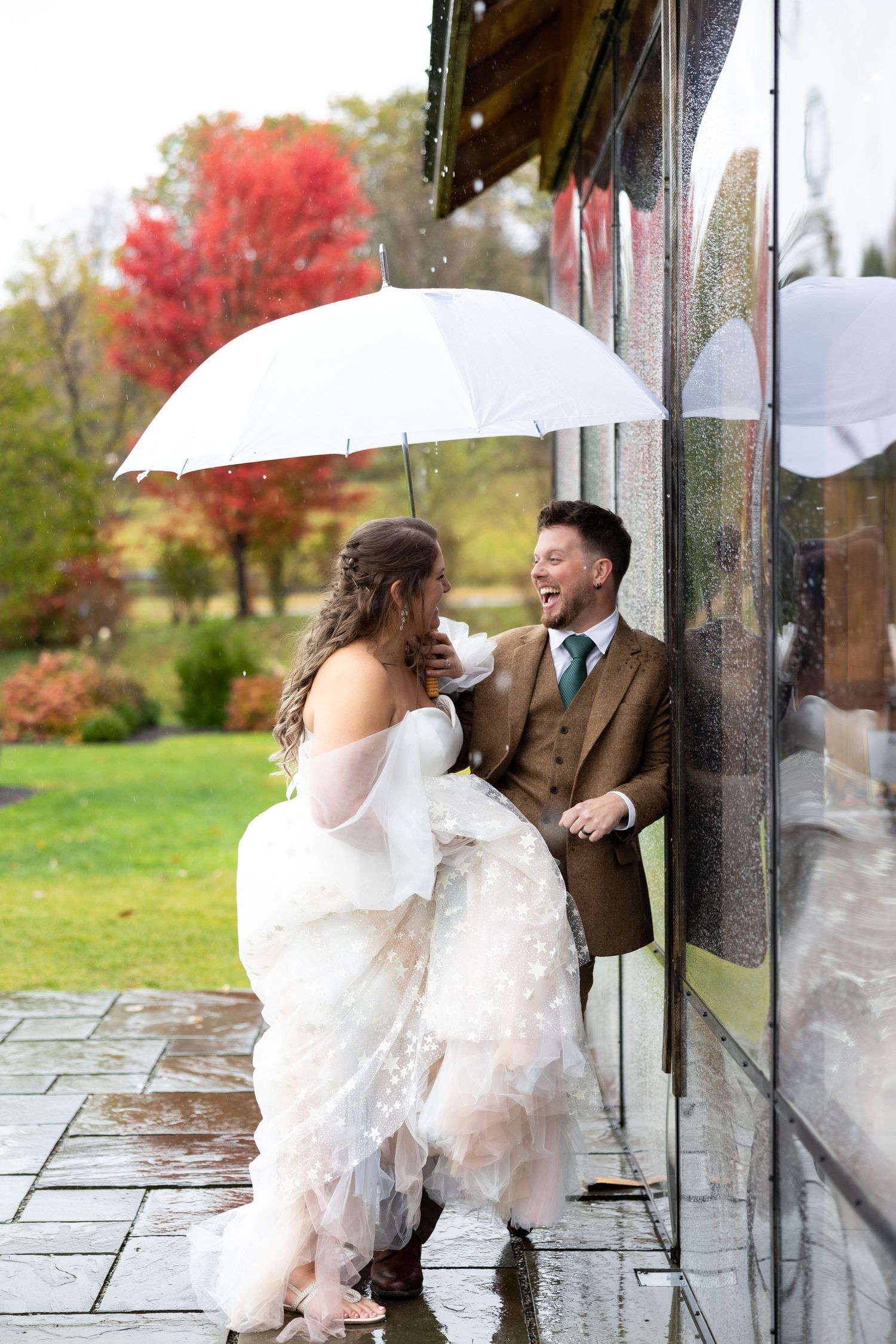 Rainy wedding day portraits under an umbrella.