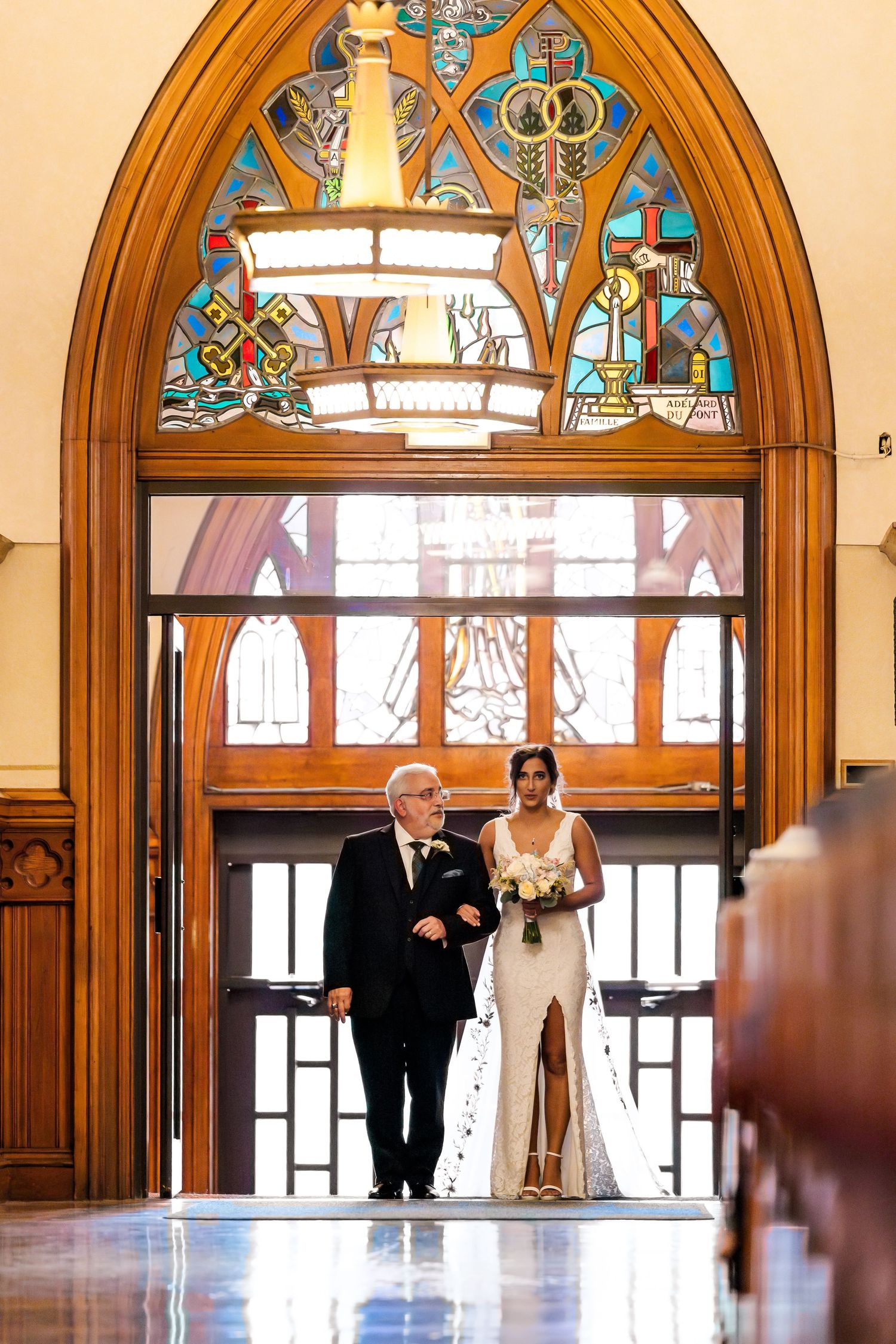 Entrance through ornate arched doorway with stained glass in traditional church.