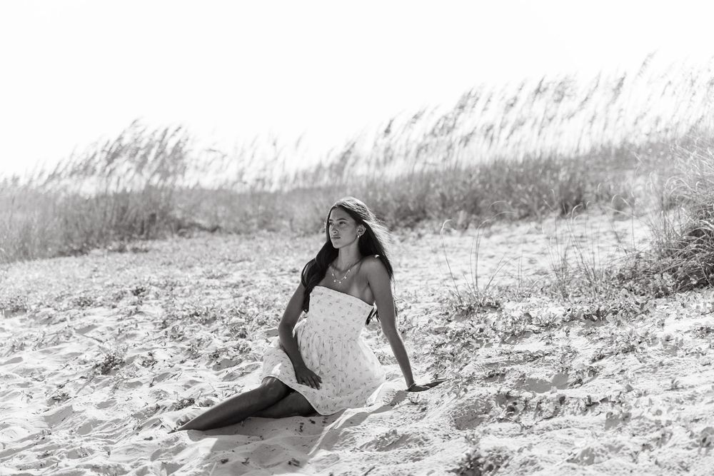 Black and white artistic photo of couple lying in tall grass.