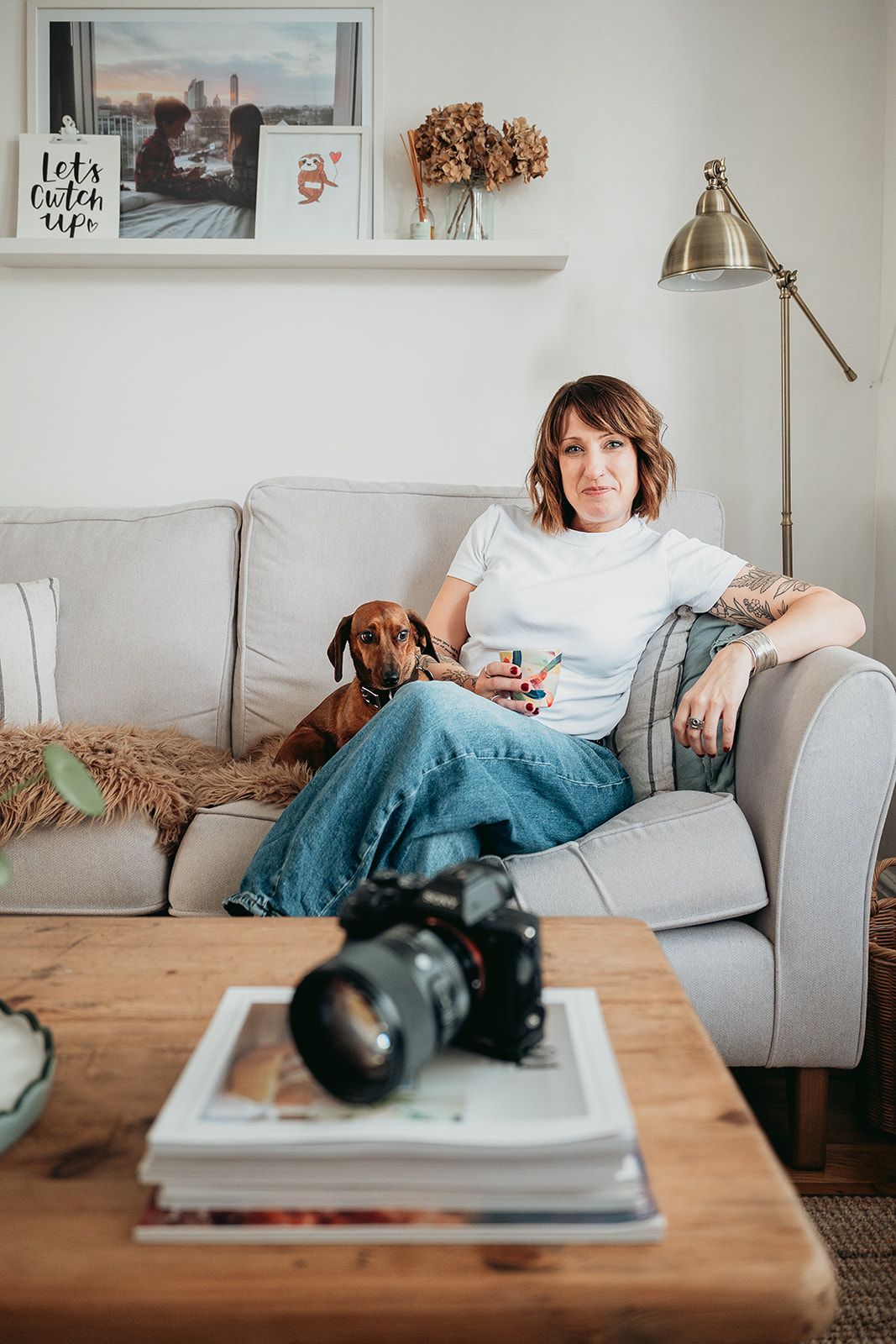Kent branding photographer at desk with images printed out looking friendly and relaxed