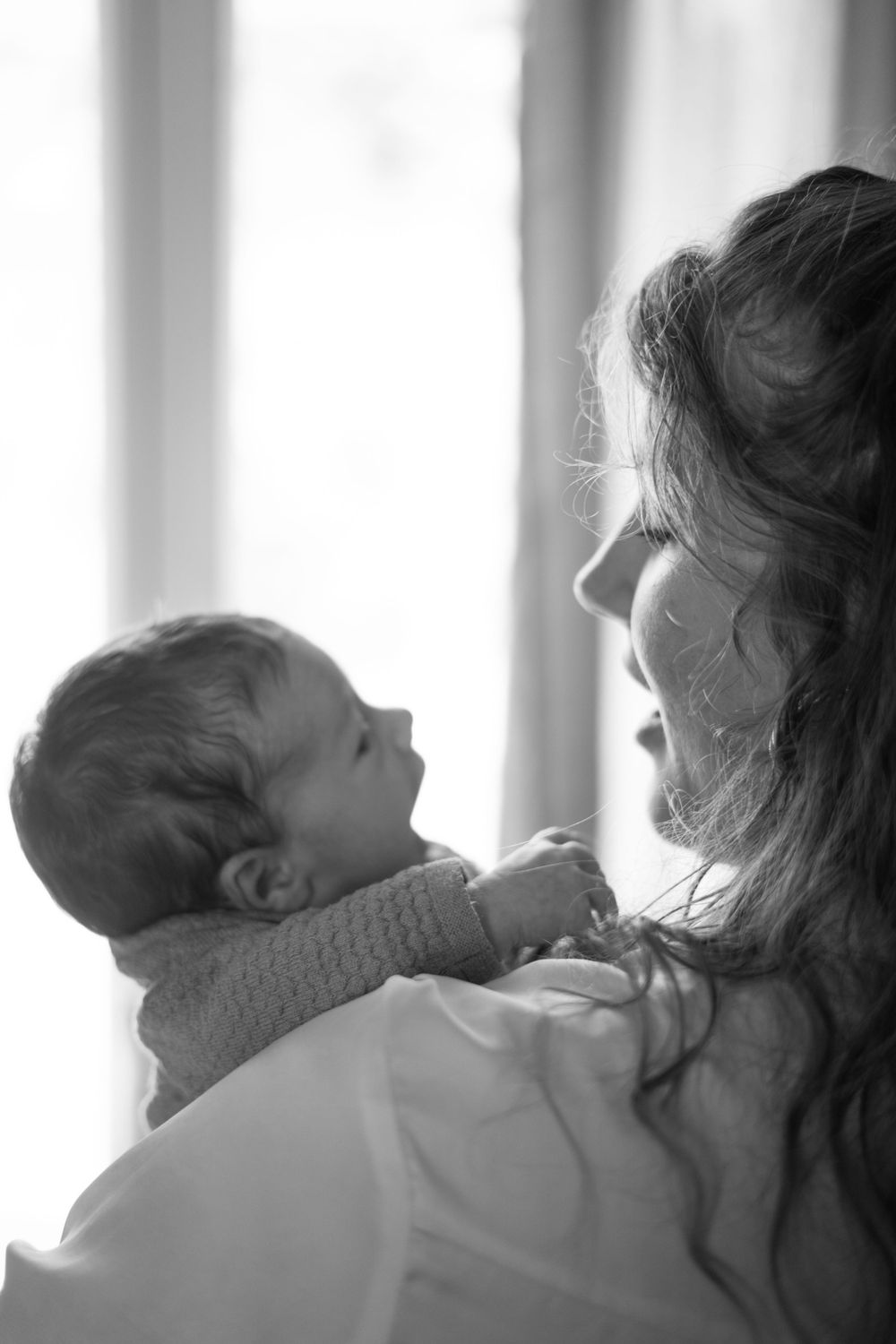 Black and white intimate portrait of tender moment between parent and baby.