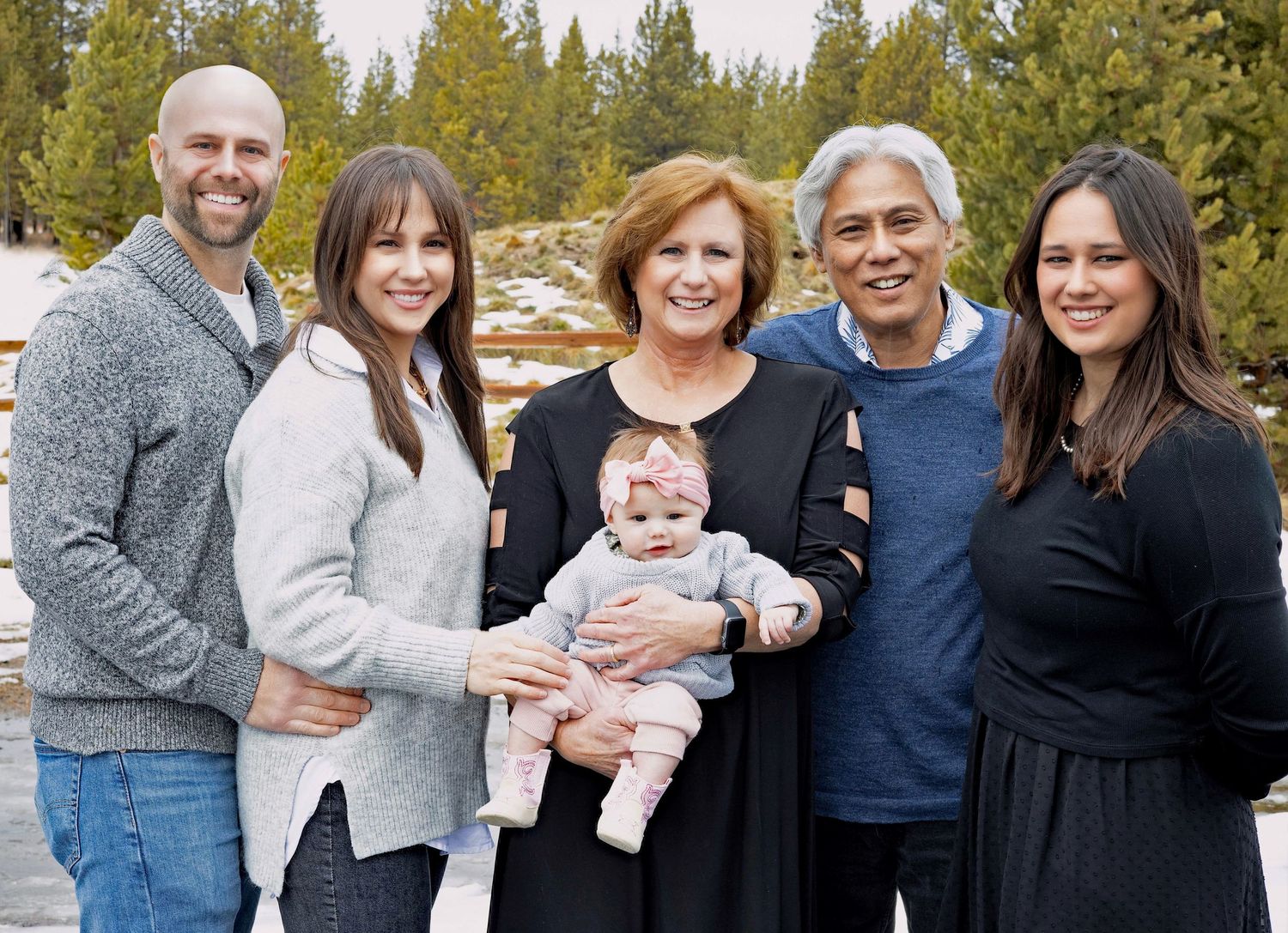 Extended family group photo outdoors with multiple generations in casual attire.