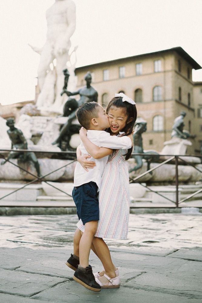children hugs in front of fontana di Nettuno in Florence