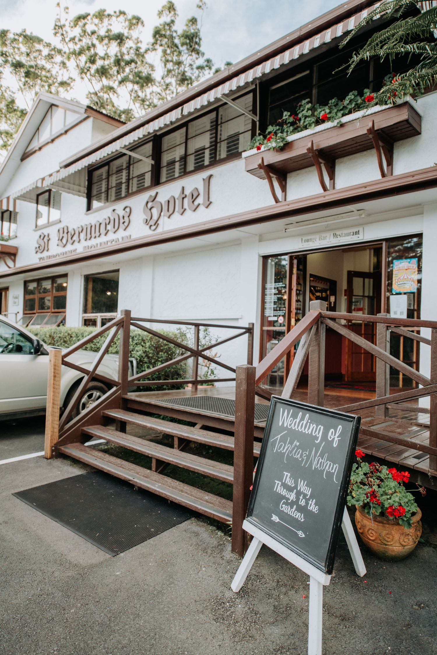 Exterior of the Braewood Hotel with wooden steps and a wedding welcome sign.