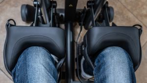 Close-up view of legs positioned in specialized exercise equipment footrests.