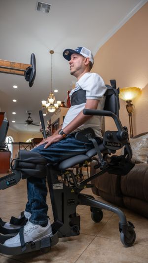 Side view of person using adaptive exercise equipment in home gym environment.
