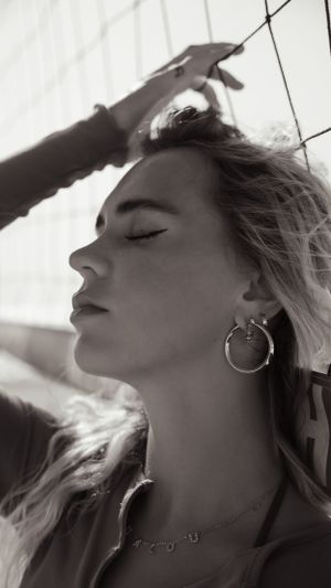 Black and white profile portrait with hoop earring and natural backlight.