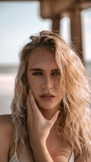 Artistic portrait of woman with flowing blonde hair in natural sunlight.