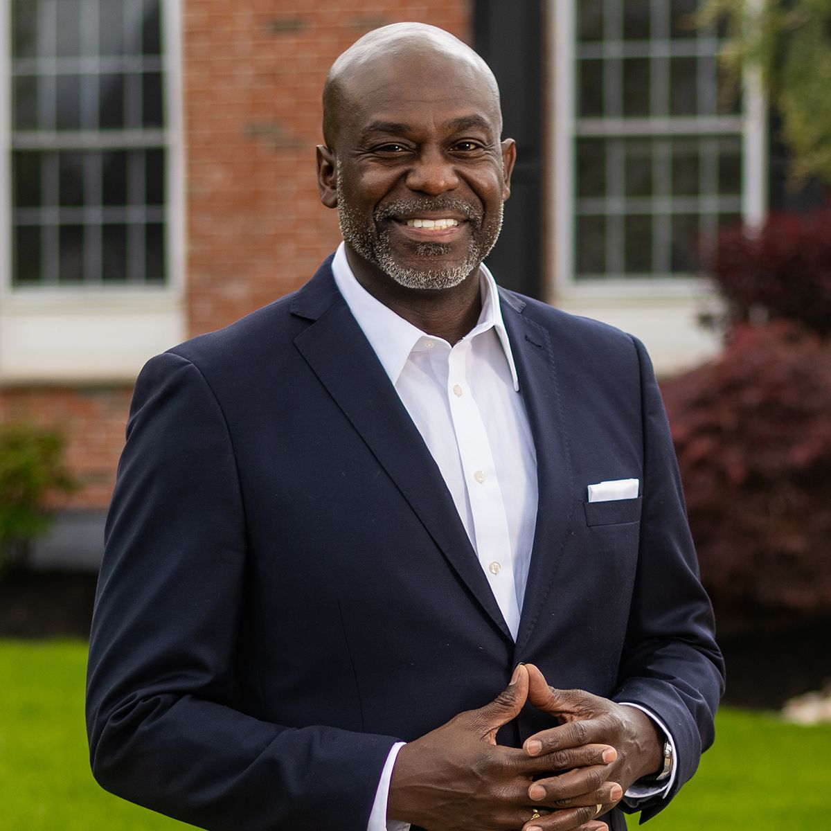 Orlando on-location headshot photographer Ray Alvarez — male executive headshot outdoors with brick building background