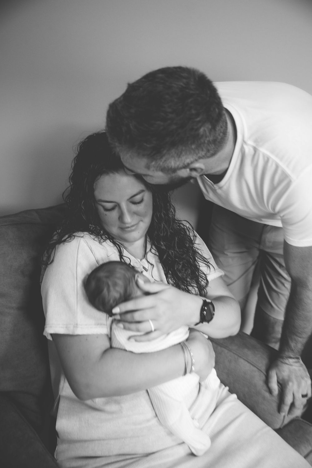 Tender moment with newborn baby in black and white photography.
