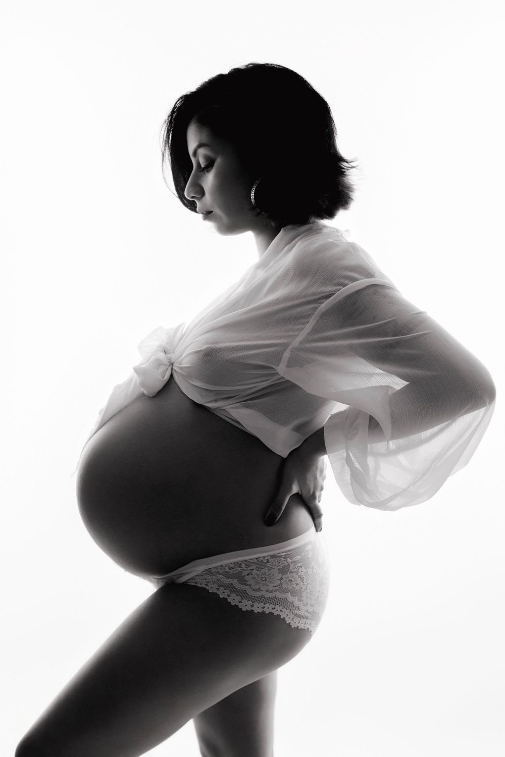 Black and white silhouette series showing pregnancy progression through artistic maternity poses against white background.