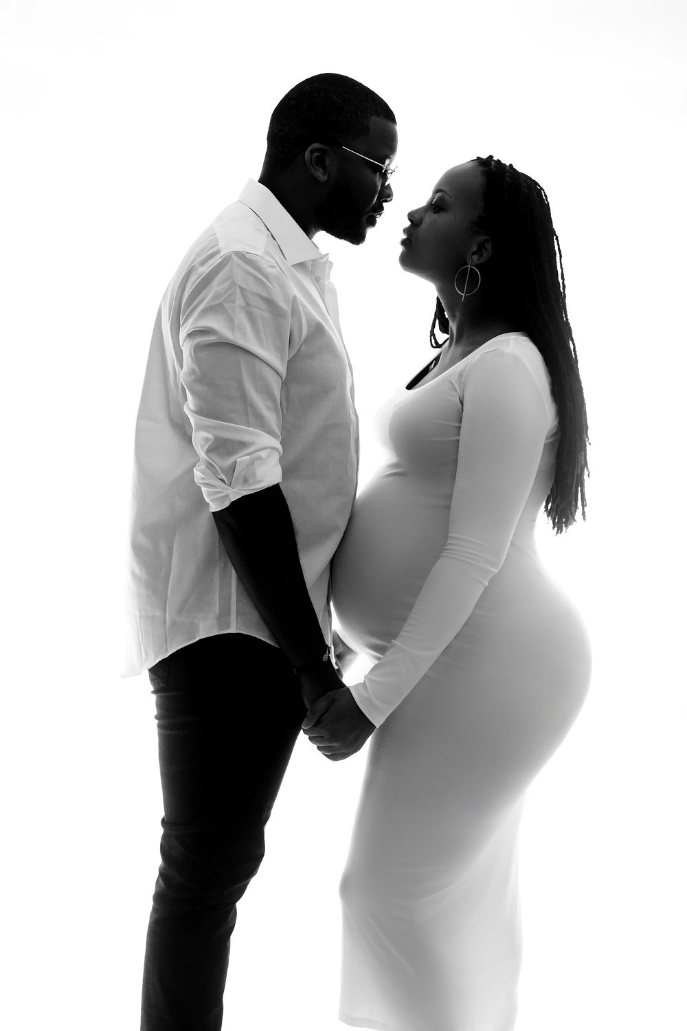Black and white artistic silhouette progression of a couple embracing during pregnancy photo shoot.