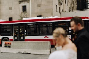 Couple walking with bus in the background. Wedding photography by Samantha Bateman.