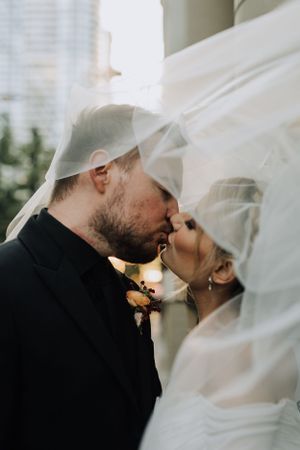 Couple kissing under veil. Wedding photography by Samantha Bateman.