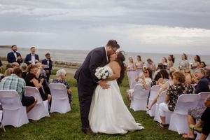 Cape Breton wedding photography, bride and groom kiss beside ocean. Wedding photography by Samantha Bateman.