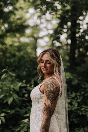 Bride standing in forest. Wedding photography by Samantha Bateman.