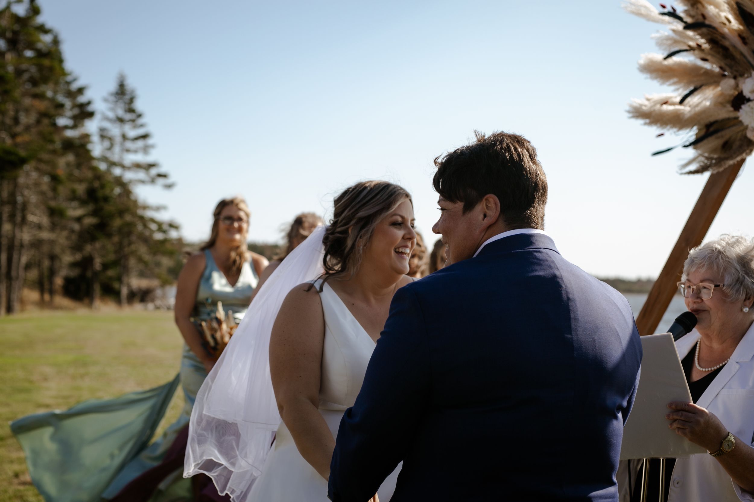 Bride and bride walking in baseball field. Photography by Samantha Bateman. Nova Scotia wedding photographer.