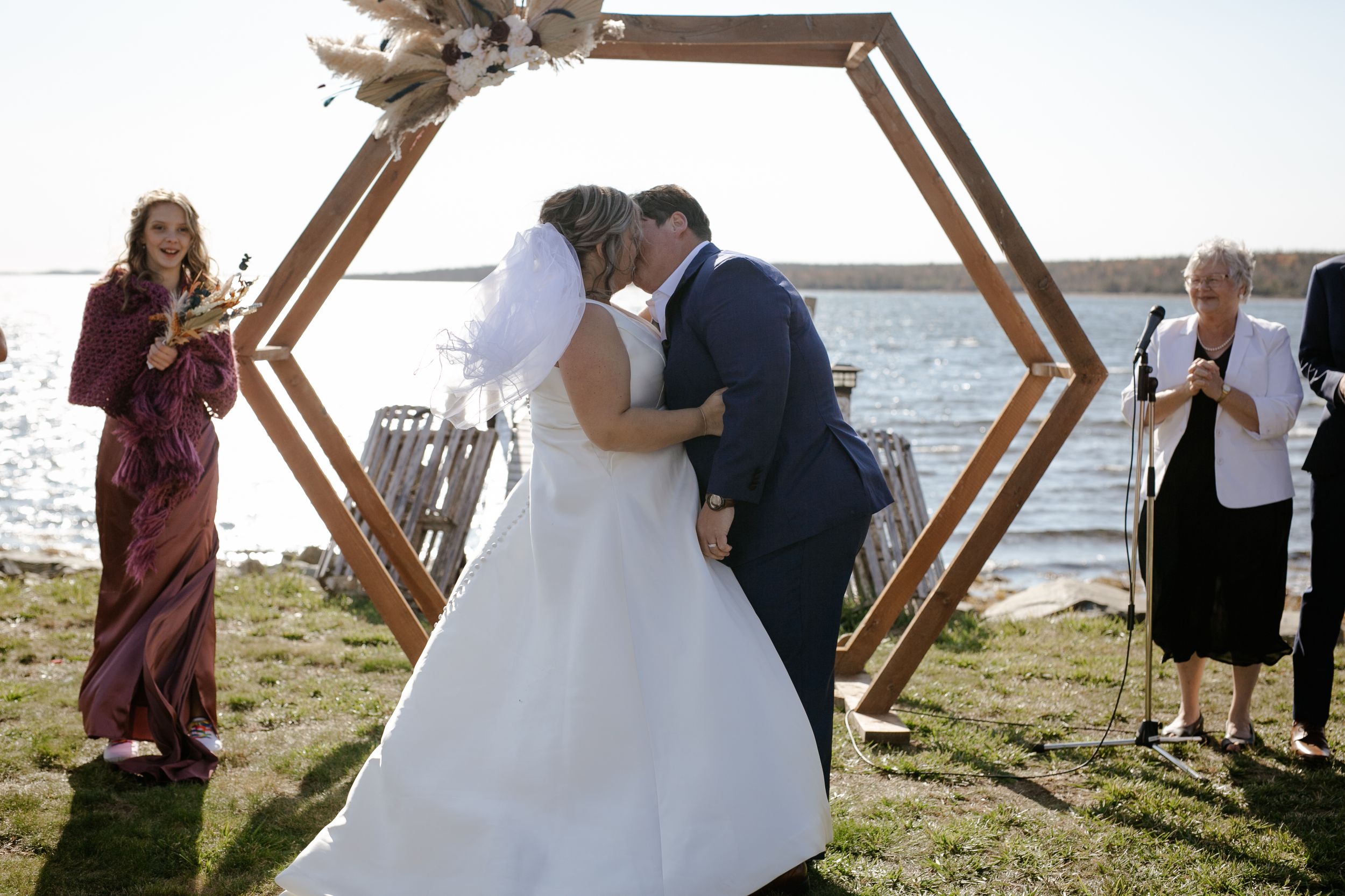 Bride and bride walking in baseball field. Photography by Samantha Bateman. Nova Scotia wedding photographer.