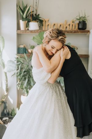 Bride giving mom a hug. Wedding photography by Samantha Bateman.