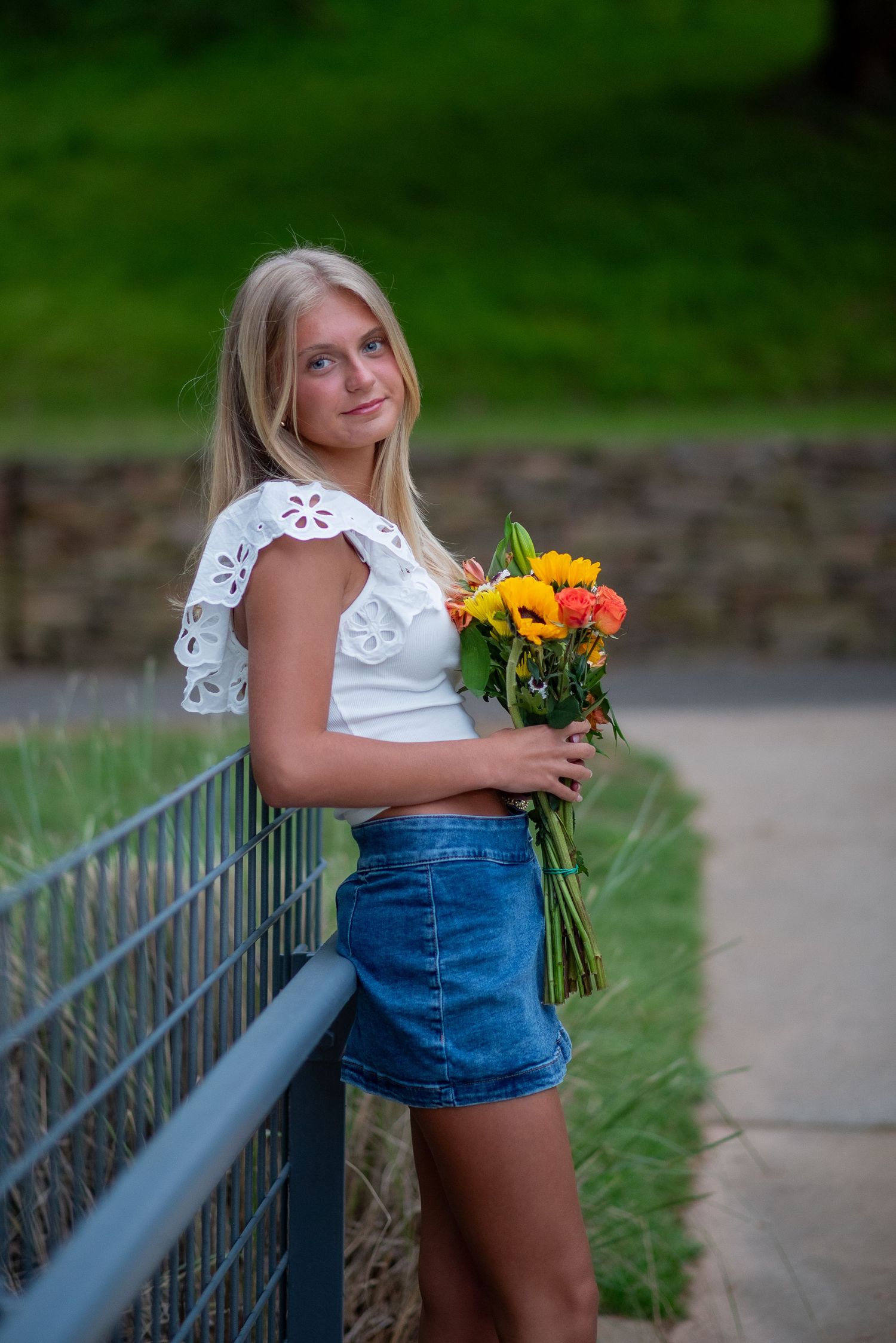 High school senior holding flowers during a golden hour senior portrait session in Raleigh, North Carolina.