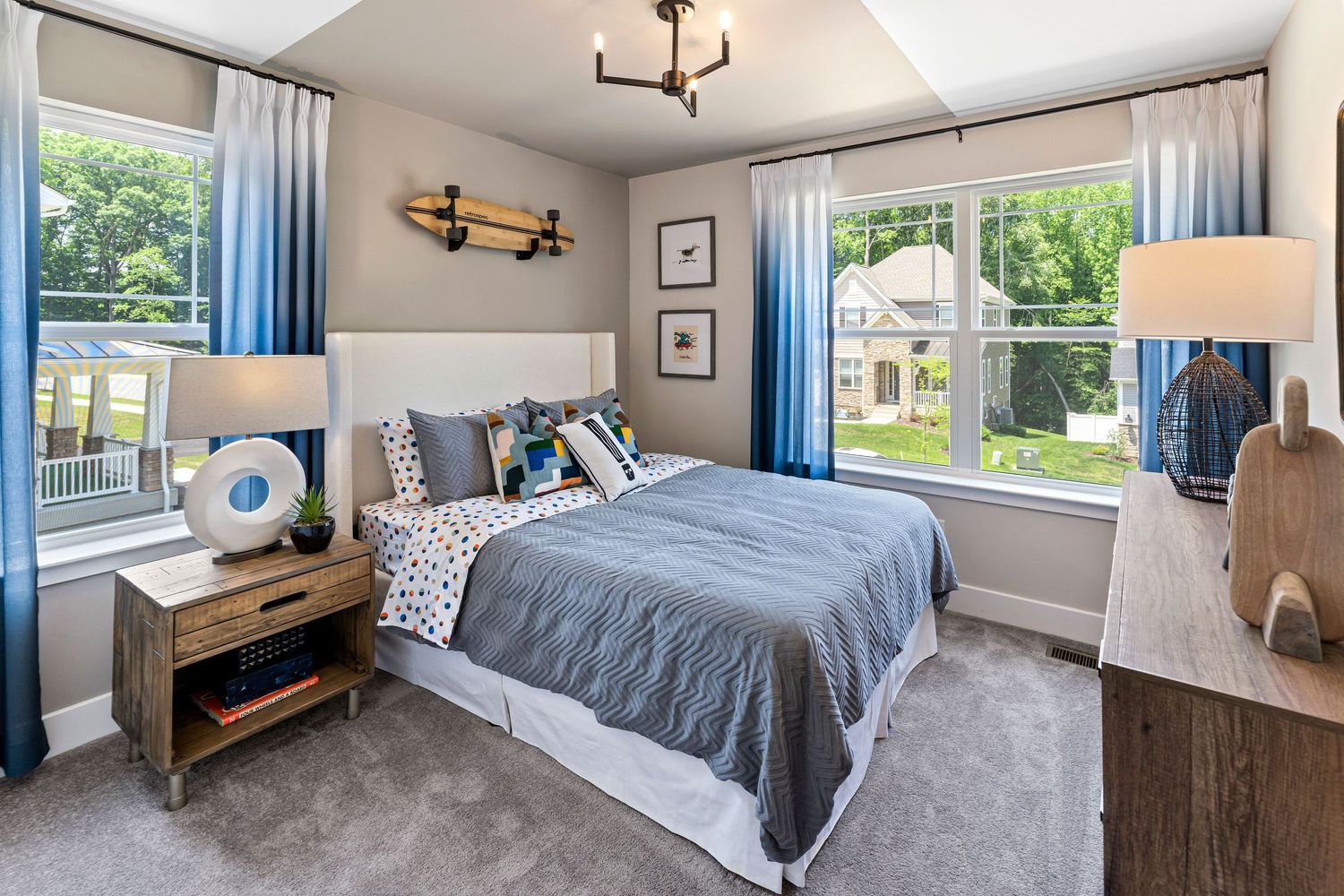 Contemporary bedroom featuring blue accents, modern lighting and hardwood floors.