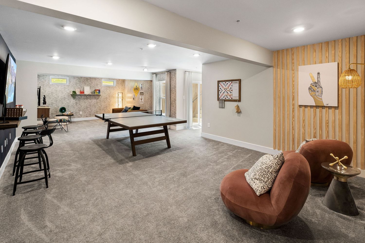 Cozy basement entertainment area with plush seating and warm lighting.