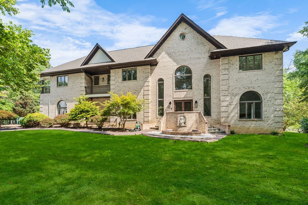Stone facade luxury home with arched windows and manicured lawn viewed from multiple angles.