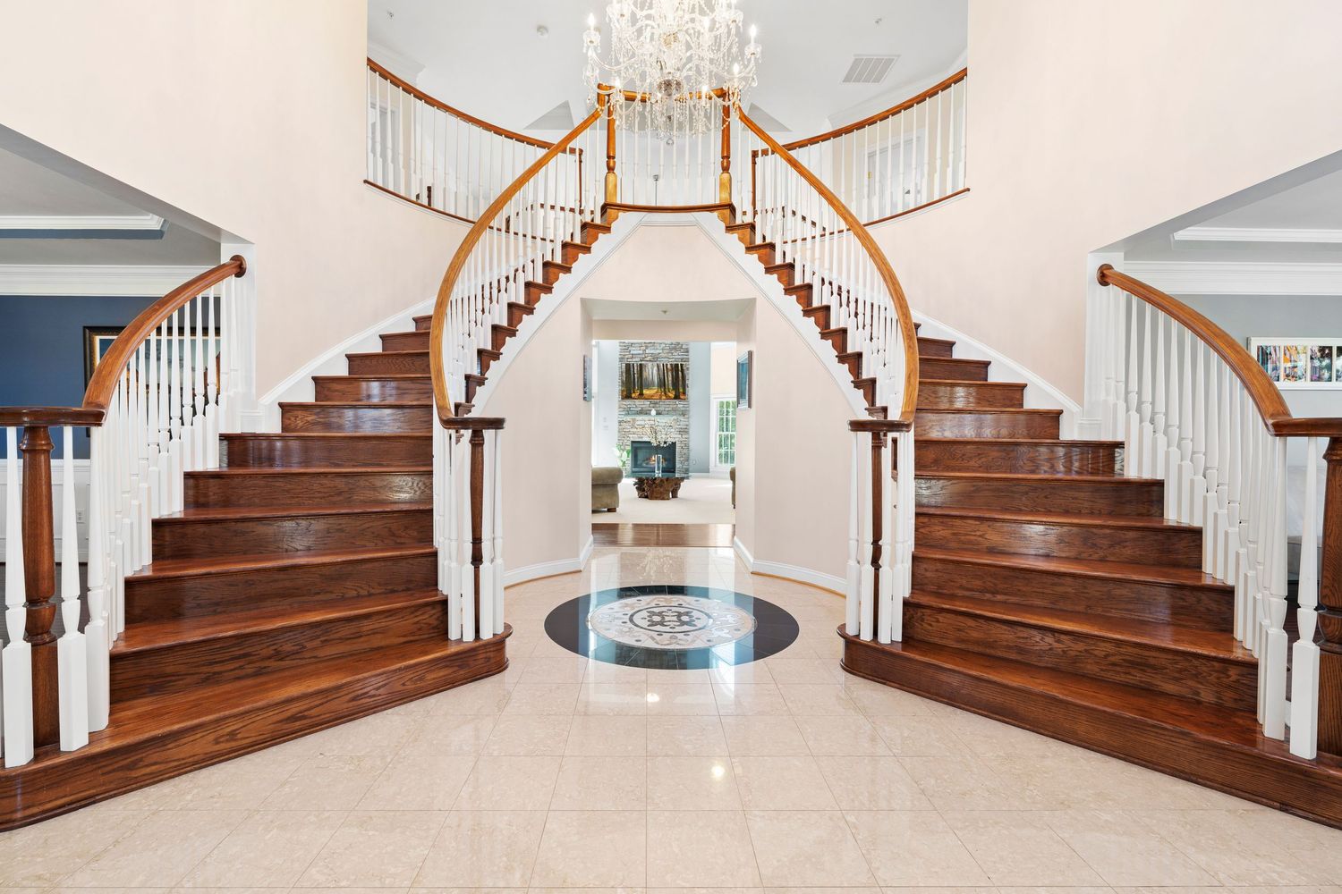 Sweeping view of elegant wooden staircase with white balusters and rich hardwood steps.