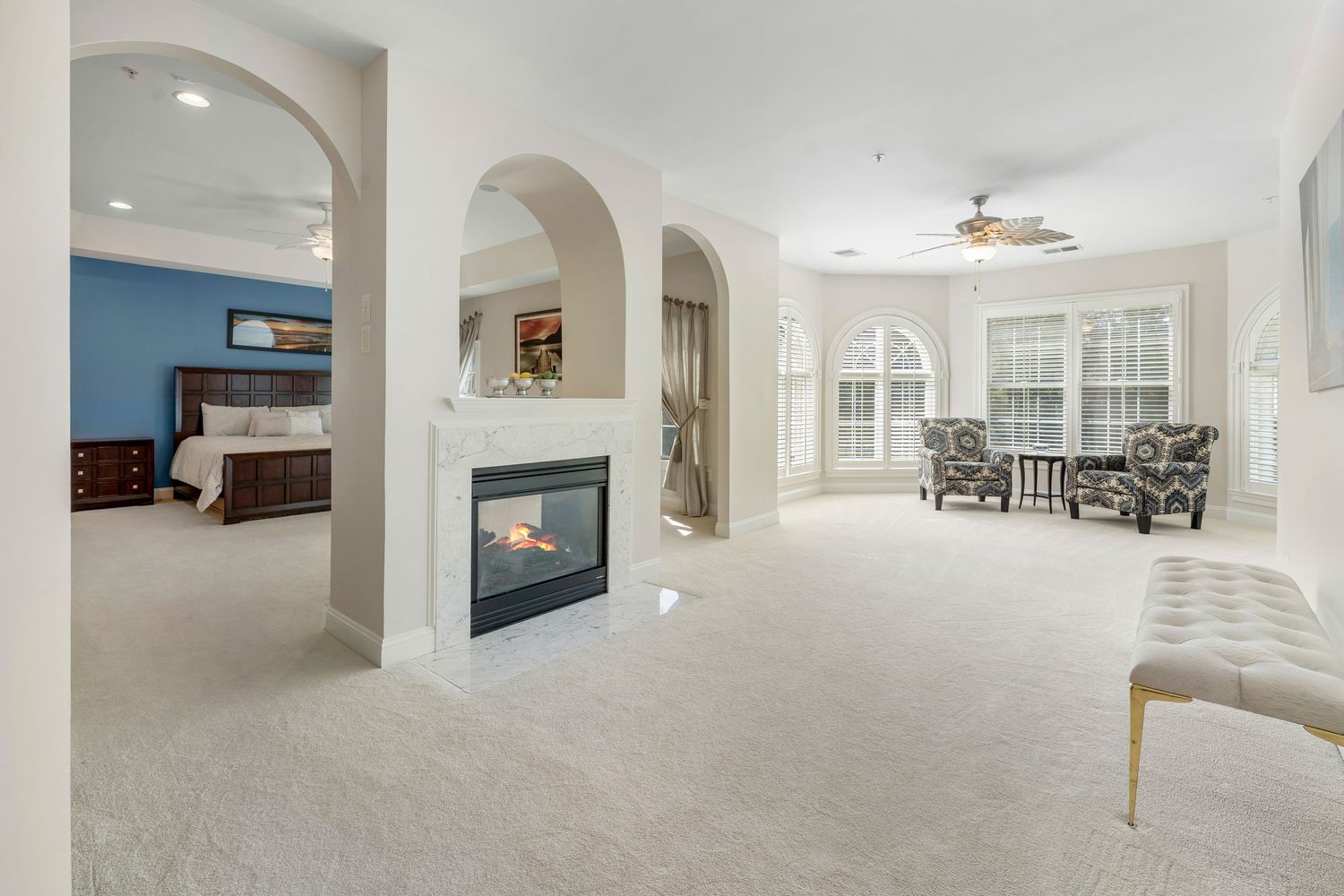 Open concept living space with white walls and arched doorways provides seamless flow between rooms.