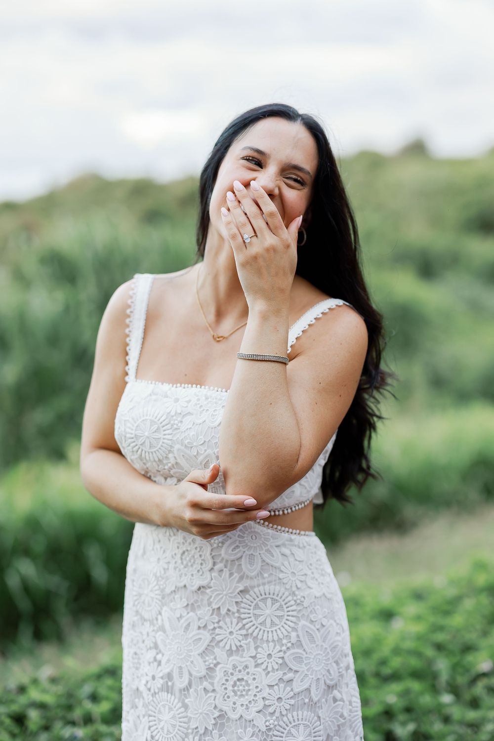 A woman covering her face with her hands, appearing to be overcome with emotion.