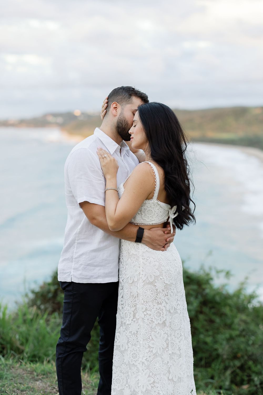 A couple embracing and gazing lovingly at each other in a scenic outdoor location.