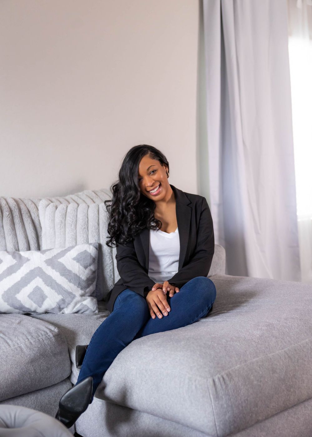 Lifestyle photoshoot on a grey couch featuring casual poses in denim and black attire.  L Visions Photography. photographer