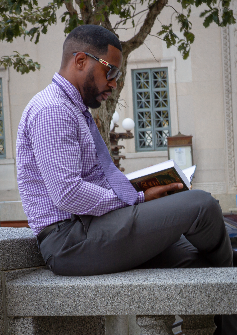 Professional sits outside on stone steps while reading.  L Visions Photography. Lifestyle photoshoot. Brandin photoshoot.
