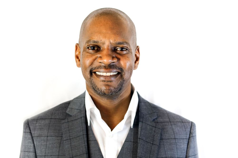 Professional headshots in grey suit and white shirt against white background. L Visions Photography. branding photoshoot. Delaware. Texas