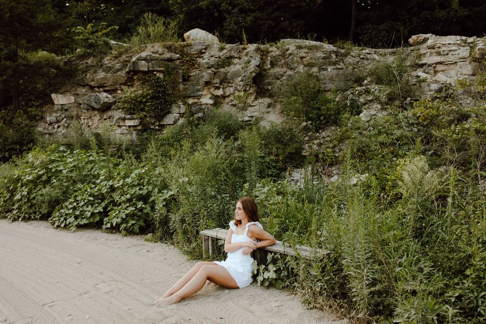 Outdoor wedding photoshoot location with natural stone walls and lush green vegetation.