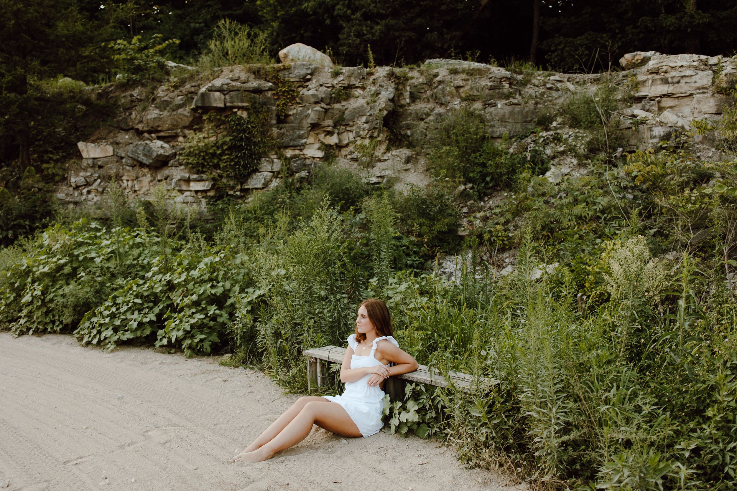 Outdoor wedding photoshoot location with natural stone walls and lush green vegetation.