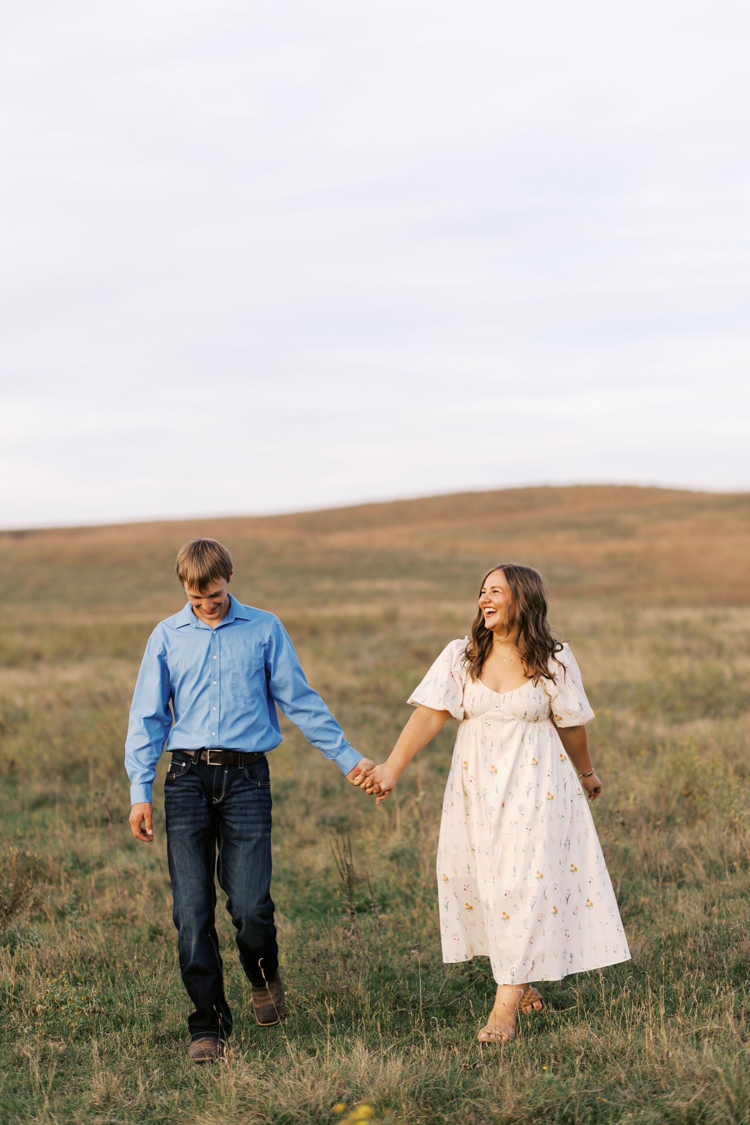 A couple sharing an intimate moment while standing in a golden wheat field at sunset.