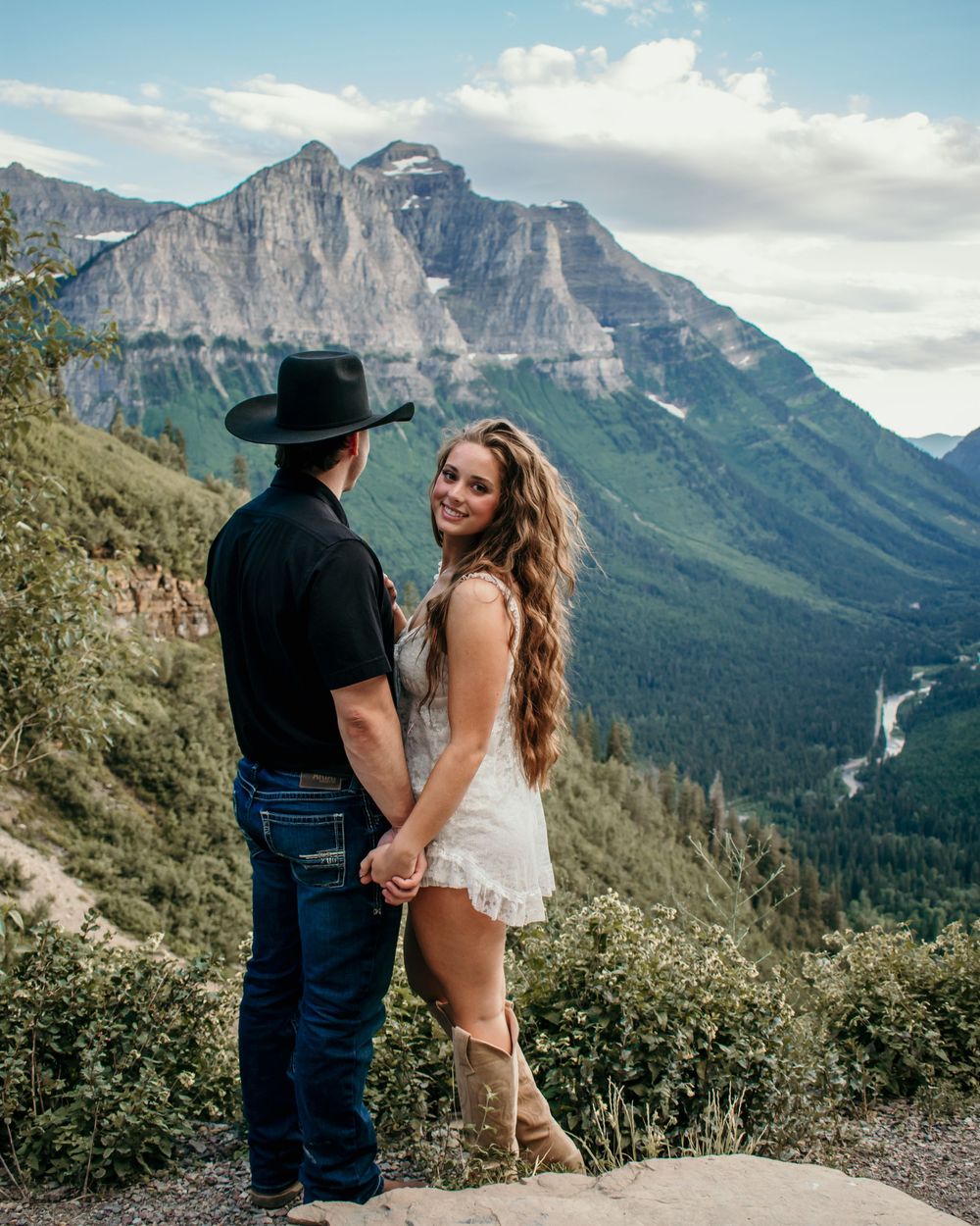 Couple enjoying scenic mountain views at sunset in a romantic outdoor setting.
