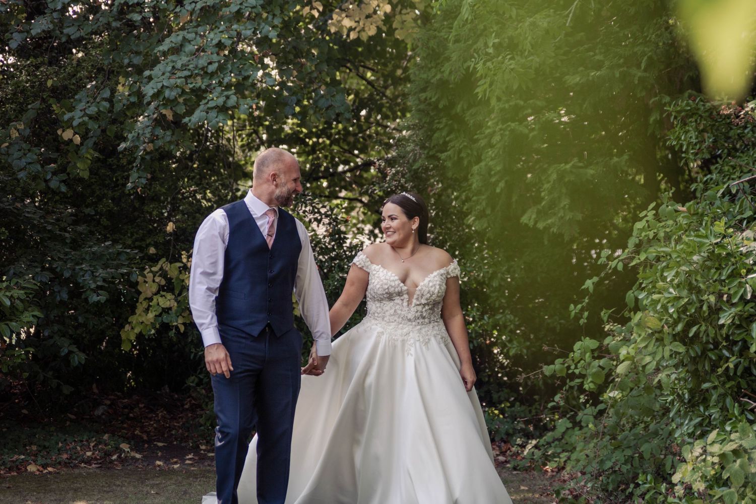 Couple celebrating in lush garden setting during special event.